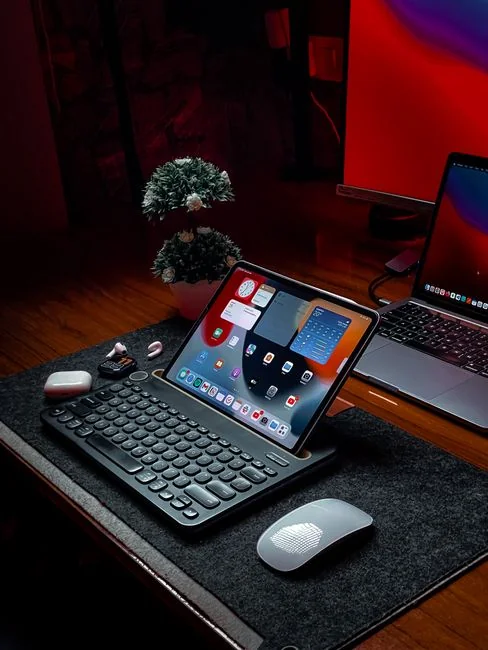 A laptop resting on a bed displays web design software, forming a cozy workspace.